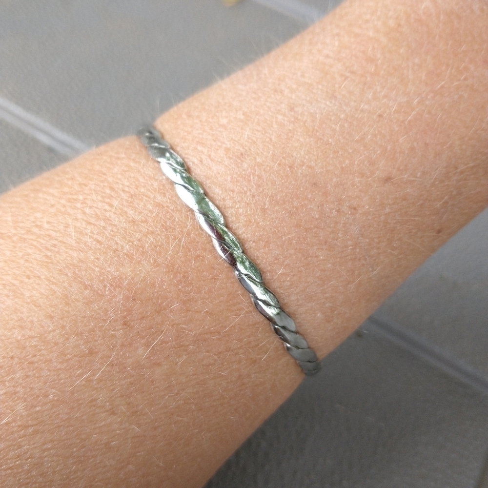 Women's thin silver tone braided bangle bracelet.